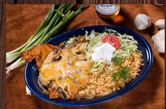 Entrée topped with melted cheese and mushrooms, with rice and salad