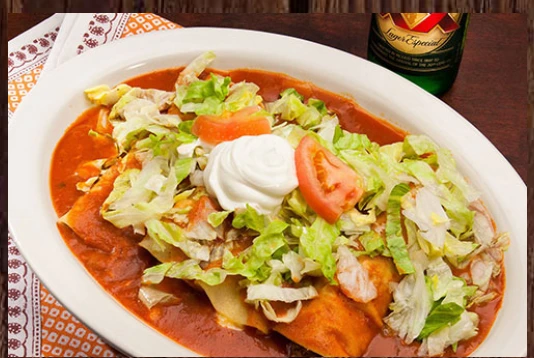 Sauced Mexican entrée topped with lettuce, tomato and sour cream