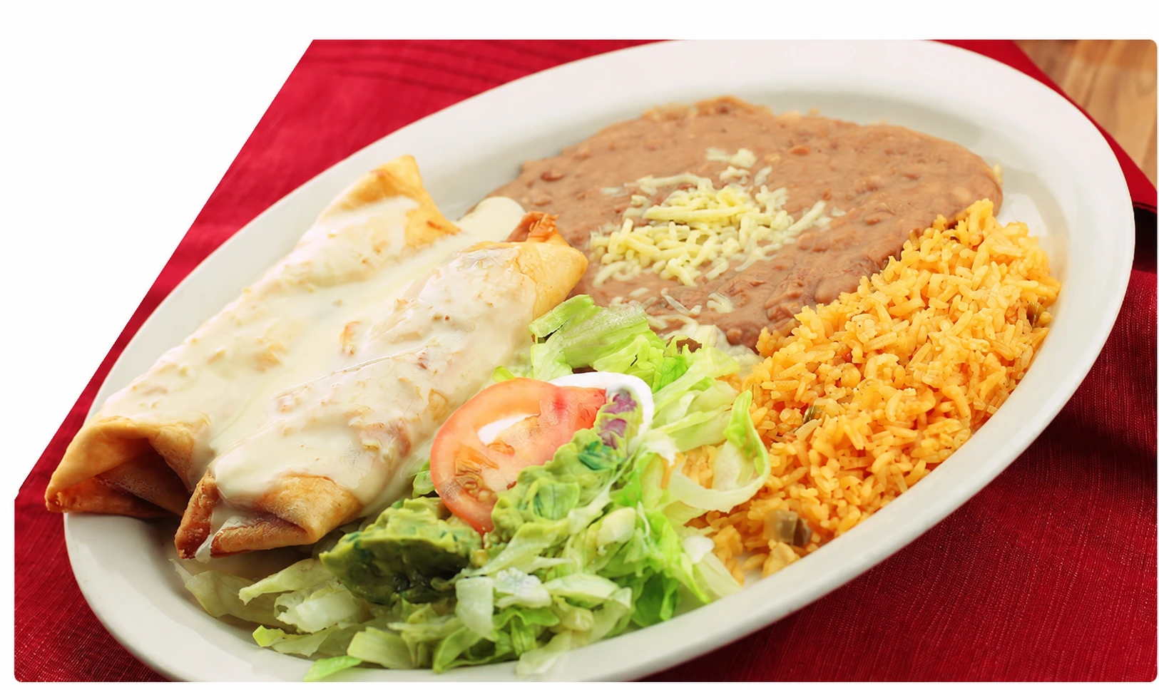 Mexican entrée with cheese sauce, refried beans, rice and salad